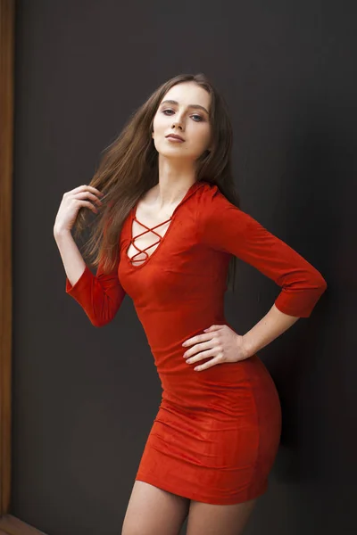 Jeune belle modèle brune en robe rouge — Photo