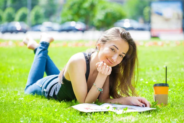 Ung vacker kvinna sitter i parken sommaren — Stockfoto