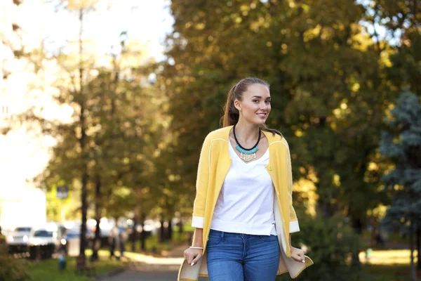 Jovem feliz em casaco amarelo na rua de outono — Fotografia de Stock