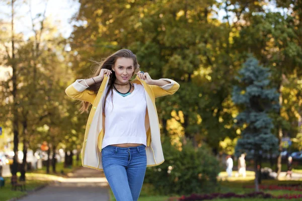 Mutlu genç kadın sokak sonbaharda sarı ceket — Stok fotoğraf
