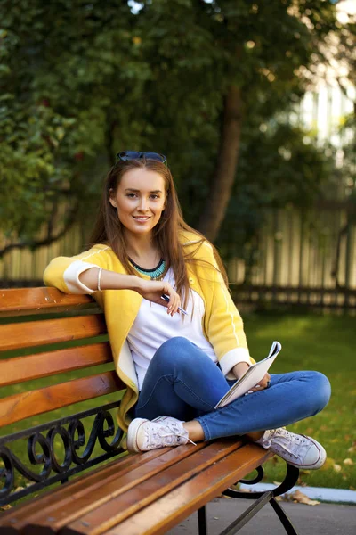 Güzel bir genç kadın sarı ceket — Stok fotoğraf