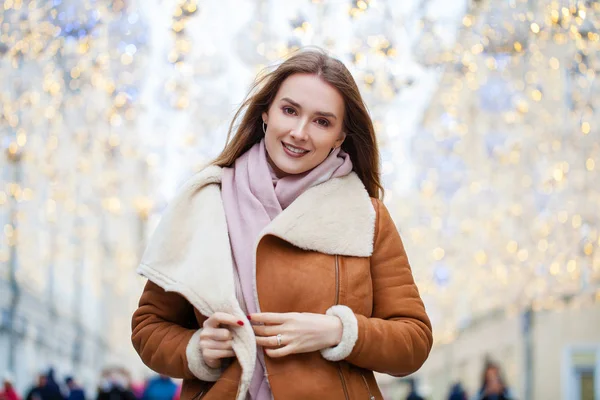 Mujer hermosa feliz en un abrigo de piel de oveja en el centro de la C —  Fotos de Stock