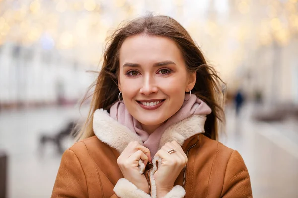 Mujer hermosa feliz en un abrigo de piel de oveja en el centro de la C — Foto de Stock