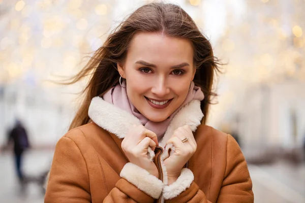 Mujer hermosa feliz en un abrigo de piel de oveja en el centro de la C — Foto de Stock