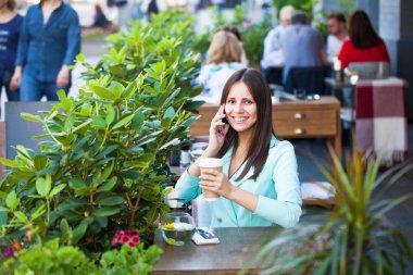 Zarif kız birini açık kafe dinlenme sırasında aramak 