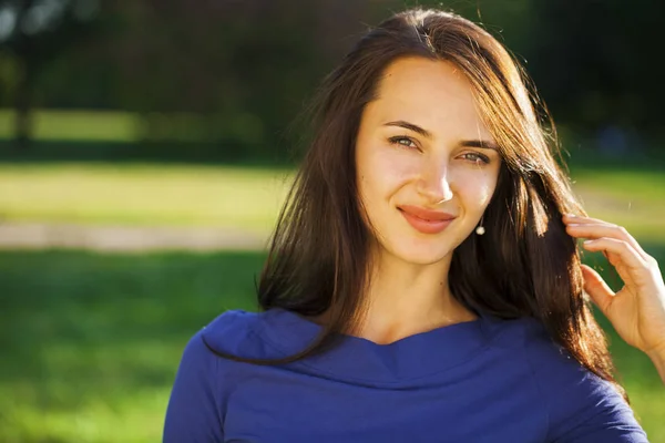 Young brunette woman in summer park — Stock Photo, Image