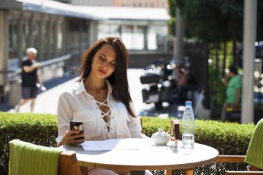 Zarif kız birini açık kafe dinlenme sırasında aramak 