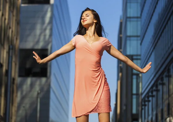 Jovem bela menina posando contra o céu azul e arranha-céus b — Fotografia de Stock