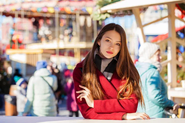 빨간 코트 겨울 공원에 포즈에 젊은 아름 다운 갈색 머리 여자 — 스톡 사진