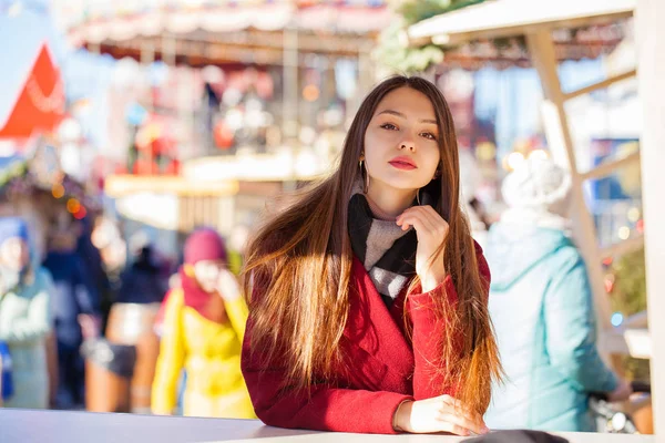 Jonge mooie brunette vrouw in rode jas poseren op winter park — Stockfoto