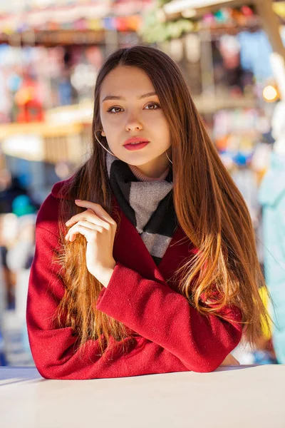 Jonge mooie brunette vrouw in rode jas poseren op winter park — Stockfoto