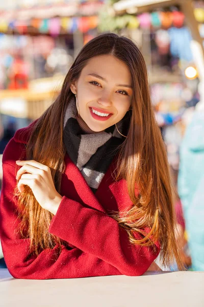 Mladá krásná brunetka žena v červeném kabátě pózuje na winter park — Stock fotografie