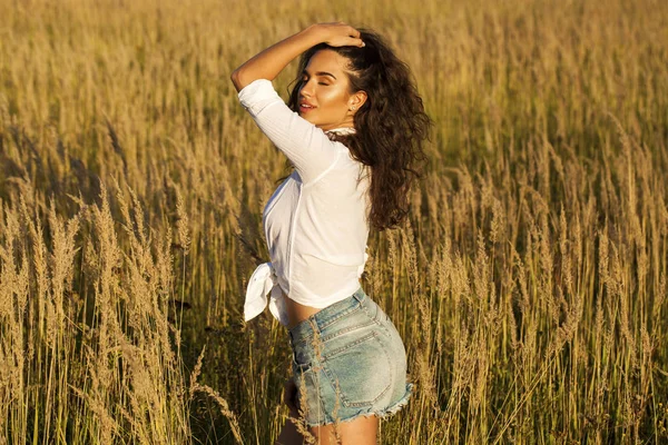 Mulher morena jovem bonita no campo — Fotografia de Stock