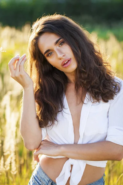 Mulher morena jovem bonita no campo — Fotografia de Stock