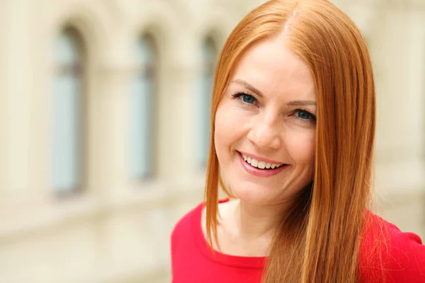 Portrait of a young red-haired woman in a red jumper — Stock Photo, Image