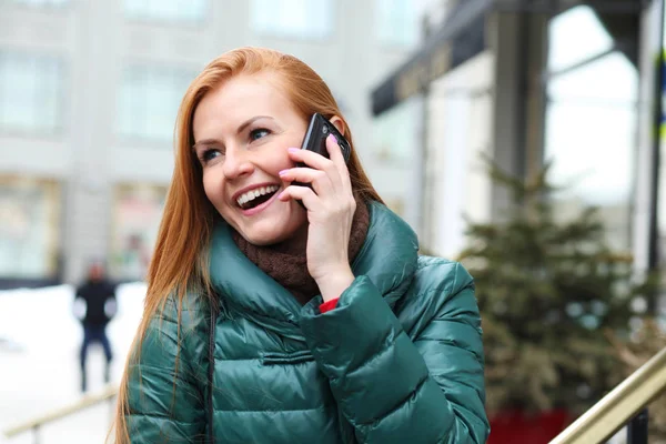 Jovem mulher de cabelo vermelho feliz chamando por telefone na rua primavera — Fotografia de Stock