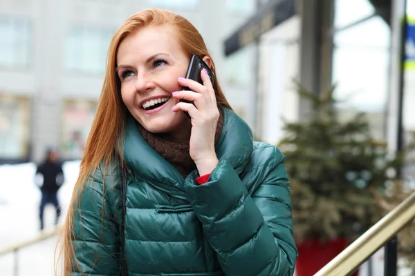 Jovem mulher de cabelo vermelho feliz chamando por telefone na rua primavera — Fotografia de Stock