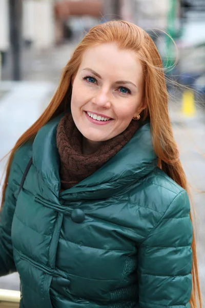 Portrait of pretty sexy young red hair woman in green down jacke — Stock Photo, Image