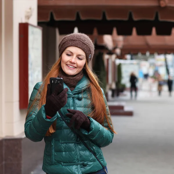 Jonge gelukkig rood haar vrouw belt telefonisch in lente straat — Stockfoto