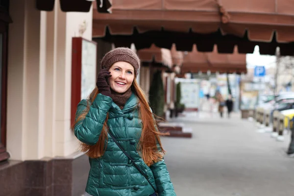 Unga glada röda hår kvinna ringer via telefon i spring street — Stockfoto