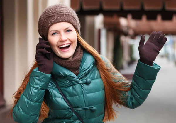 Young happy red hair woman calling by phone in spring street — Stock Photo, Image