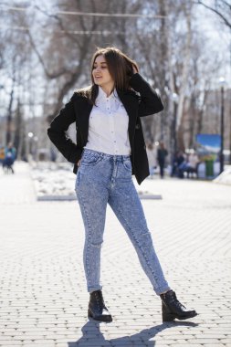 Genç kız içinde beyaz gömlek ve mavi kot Walks içinde Spring Park