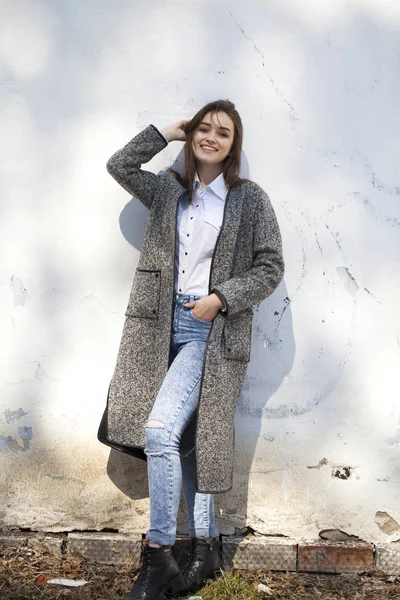 Tiener meisje in een grijze jas en blauwe jeans — Stockfoto