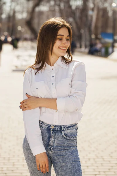 Joven hermosa chica morena en camisa blanca posando en primavera pa —  Fotos de Stock