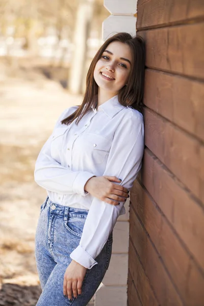 Šťastná dívka v bílé košili na dřevěné stěně — Stock fotografie