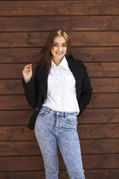 Menina adolescente feliz em uma camisa branca em um fundo de parede de madeira — Fotografia de Stock