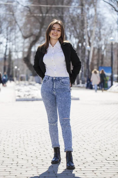 Teen Girl w białej koszulce i niebieskie dżinsy spacery w parku wiosennym — Zdjęcie stockowe