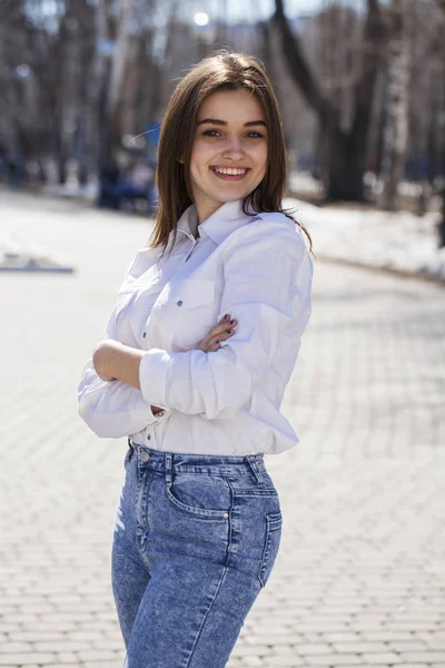 Junge schöne brünette Mädchen in weißem Hemd posiert auf Frühling pa — Stockfoto