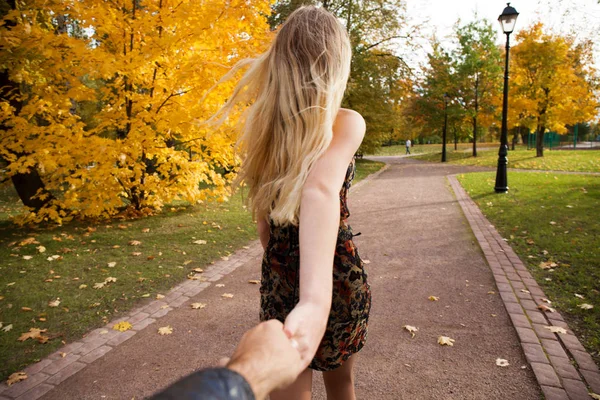 Beautiful young blonde and holding the hand of unidentified man — Stock Photo, Image