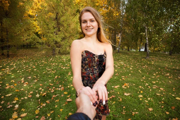 Beautiful young blonde and holding the hand of unidentified man — Stock Photo, Image