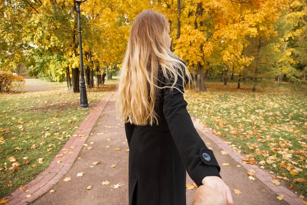 Beautiful young blonde and holding the hand of unidentified man — Stock Photo, Image