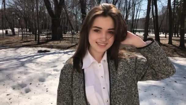 Vacker brunett flicka i grå päls poserar på Spring Park — Stockvideo
