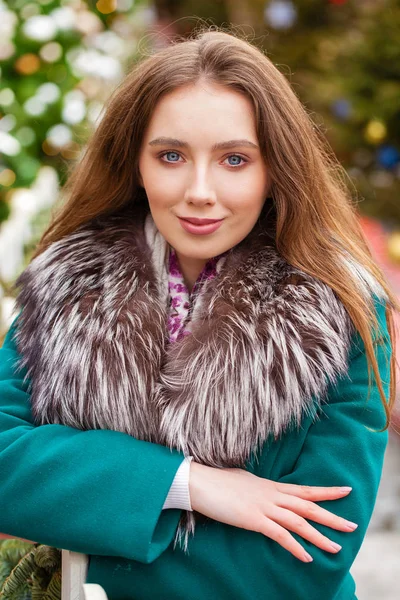 Mujer morena joven feliz en un abrigo verde con un collar de piel, wi —  Fotos de Stock