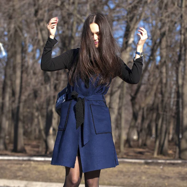 Портрет молодой красивой женщины в синем пальто с мешком прогулки — стоковое фото