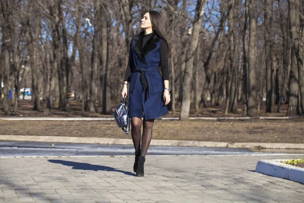 Portrait d'une jeune belle femme en manteau bleu avec une promenade en sac — Photo