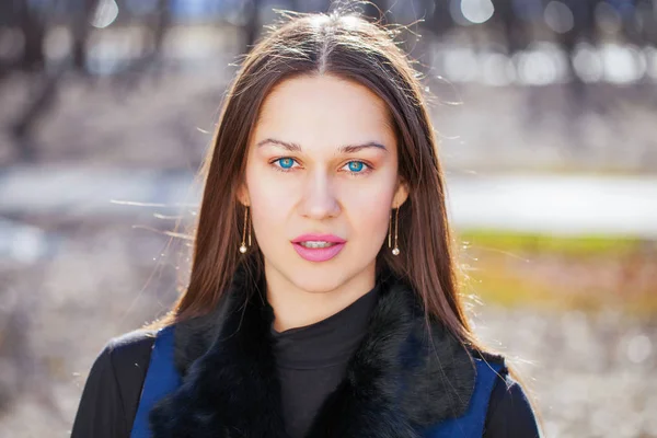 Bahar parkında mavi ceketli genç ve güzel bir kadının portresi — Stok fotoğraf