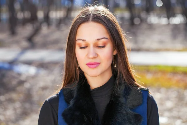 Retrato de una joven mujer hermosa con abrigo azul en el parque de primavera — Foto de Stock