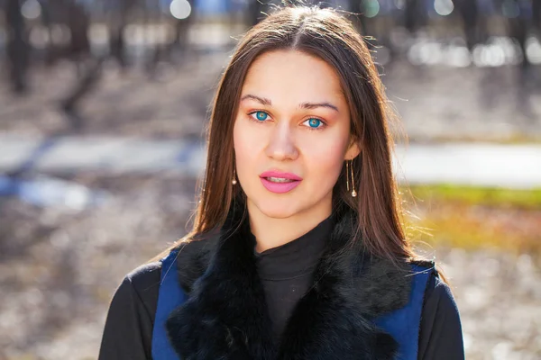 Retrato de uma jovem bela mulher de casaco azul no parque primaveril — Fotografia de Stock