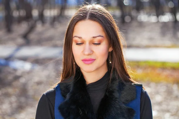 Retrato de una joven mujer hermosa con abrigo azul en el parque de primavera — Foto de Stock