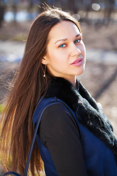 Retrato de uma jovem bela mulher de casaco azul no parque primaveril — Fotografia de Stock