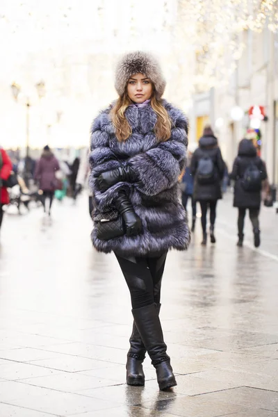 Retrato de una niña con un extravagante abrigo de piel azul en un invierno p — Foto de Stock