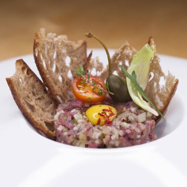Mermer biftek tartare beyaz bir plaka üzerinde