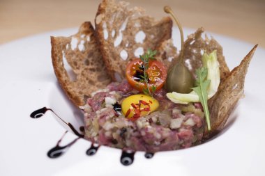 Mermer biftek tartare beyaz bir plaka üzerinde