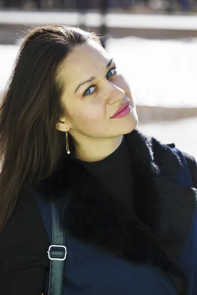Retrato de uma jovem bela mulher de casaco azul no parque primaveril — Fotografia de Stock