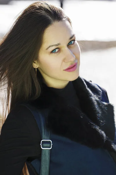 春の公園で青いコートを着た若い美しい女性の肖像 — ストック写真