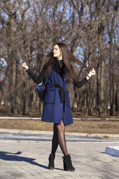 Ritratto di una giovane bella donna in cappotto blu con una passeggiata borsa — Foto Stock